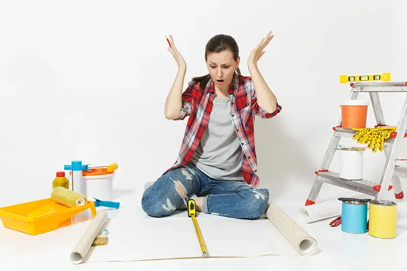 Zdziwiona kobieta przy pracy remontowej