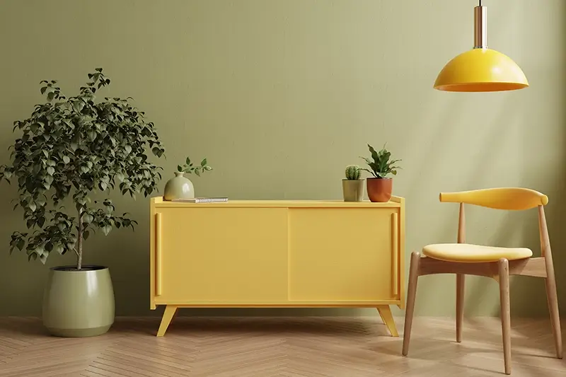 Salon z zieloną ścianą i żółtymi meblami