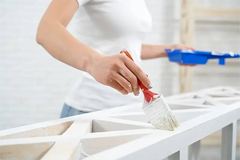 Kobieta maluje półkę