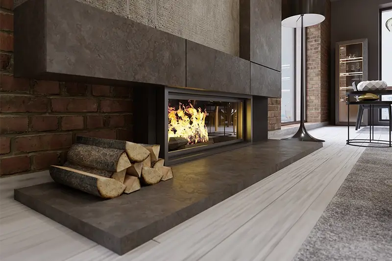 Wnętrze domu z kominkiem na tle ściany z cegły i kamienia