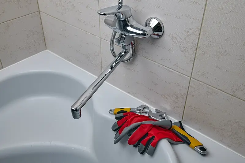 Regulowane klucze hydrauliczne i rękawice w łazience przy kranie