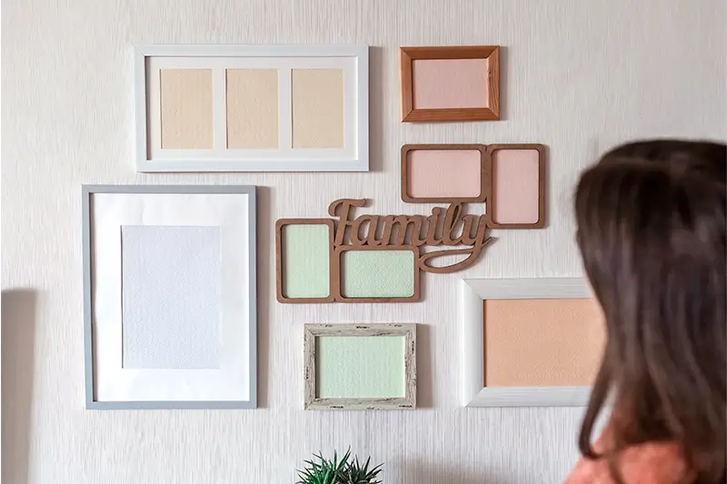 Kobieta patrzy na różne ramki na ścianie