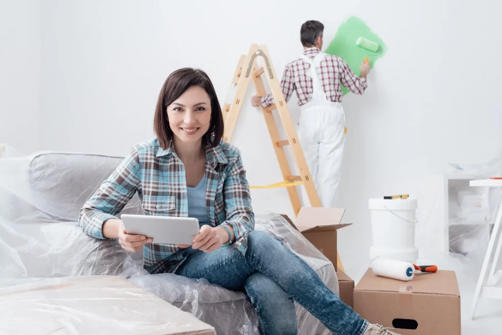 Kobieta siedzi z tabletem na kanapie podczas remontu